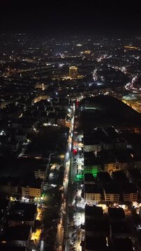 Aerial night view of an urban landscape in Syria featuring glowing city lights and illuminated streets.  Post-war Syrian cityscape and daily life at night.