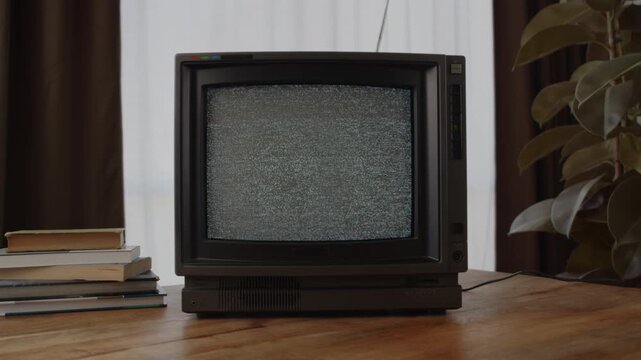 Retro TV, vintage television In a nostalgic setup, a retro TV displays grain on screen, scary halloween night device good for chroma key and green screen.