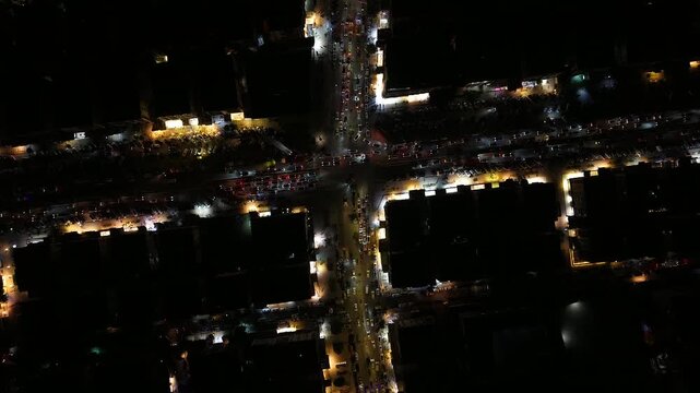 Aerial night view of an urban landscape in Syria featuring glowing city lights and illuminated streets.  Post-war Syrian cityscape and daily life at night.