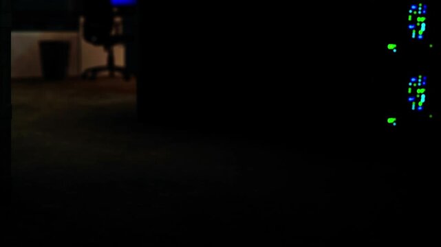 A room filled with servers and lights. One chair is visible in the background. The scene is dimly lit, showing the technology in use at night, suggesting an operating environment.