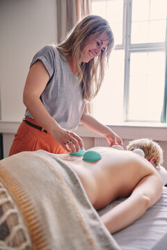 Smiling therapist doing a cupping treatment
