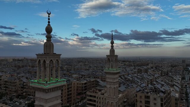 Aerial drone view of an Islamic mosque featuring a prominent dome and tall minarets. Concept of world religions, faith, and Islamic culture in post-war Syria.