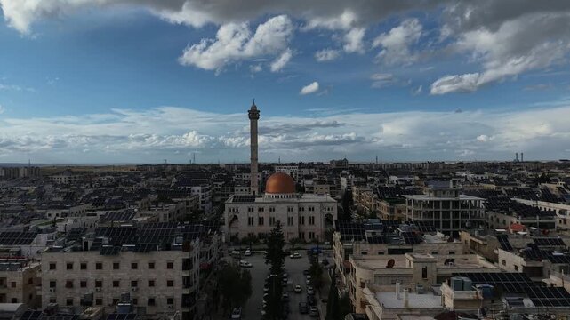 Aerial drone view of an Islamic mosque featuring a prominent dome and tall minarets. Concept of world religions, faith, and Islamic culture in post-war Syria.