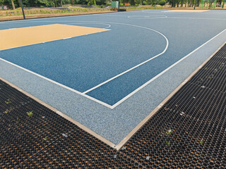 Fototapeta premium New outdoor basketball court with a artificial playground and sports flooring. Polymeric Rubber Surfacing called tartan flooring