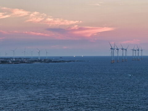 Aerial view of offshore wind turbines along the coastline during sunset in South Korea.