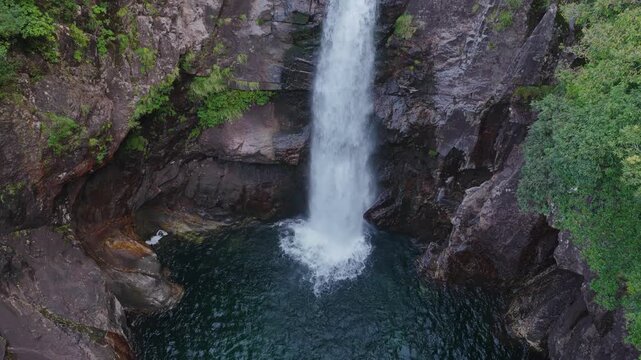Flying over waterfall and natural pools in rock canyon on Yakushima, Japan