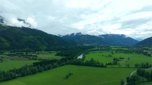 Aerial view of Nationalpark Gesause and Hochtor Peak with lush green meadows and the Enns river in Admont, Steiermark, Austria.