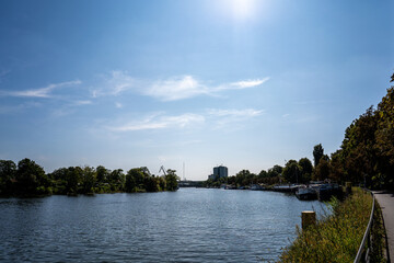 Fototapeta premium Wide view of inland port with harbor crane, boat and bridge under blue sky in Berlin Spandau Germany with copy space