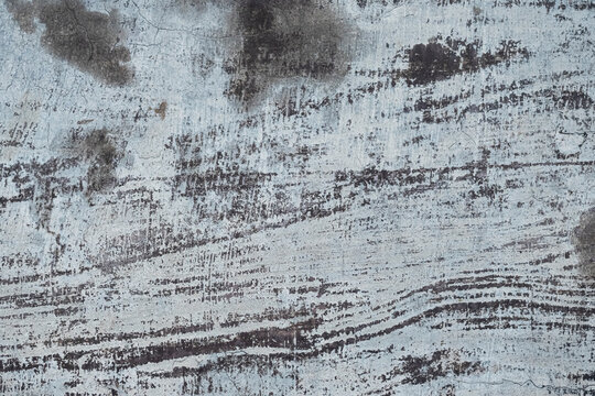 Old and moldy iron wall background. The surface of the white steel plate wall is moldy. The texture of the surface of the steel plate wall. Close-up view of an old, weathered wall surface