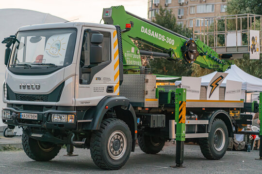 Summary A white and black utility vehicle with a crane attachment, primarily featuring yellow caution markings and the DASAN logo The crane ends in a hook with a - Kyiv, Ukraine - June 7, 2025