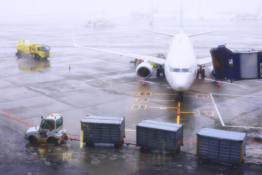 The plane at the airport: preparation for departure next to the terminal, baggage loading.
