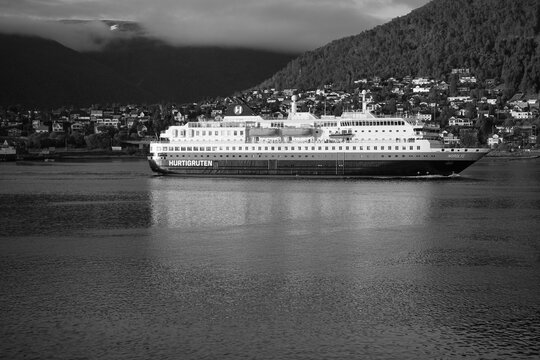 Tromso, Norway, June 19th 2026: A Hurtigruten ship lies alongside the harbor in Troms&oslash;, with the striking Arctic Cathedral rising across the water, capturing the unique blend of maritime heritage	