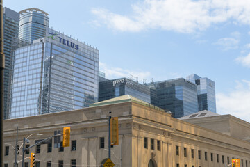 Fototapeta premium contrast of architectures: TELUS Harbour corporate office and historic Union Station complex, looking southwest from Bay and Front, Toronto