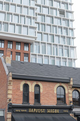 Fototapeta premium historical architecture with sign of Harvest Wagon, a gourmet grocery store (1103 Yonge St) and recently constructed condominium The James (10 Price St) Toronto