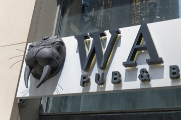 Fototapeta premium exterior building facade and novelty sign outside Walrus Pub & Beer Hall, a restaurant, located at 187 Bay St, Toronto