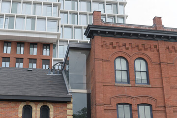 Fototapeta premium shops of Summerhill, 1095-1103 Yonge St, originally constructed c 1892, commercial row buildings contrast with The James, a condominium complex, in Toronto