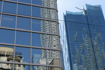 Fototapeta premium mirror windows with reflection of old and new architecture and (at right) CIBC Square (looking south on Yonge St at Wellington St E), Toronto