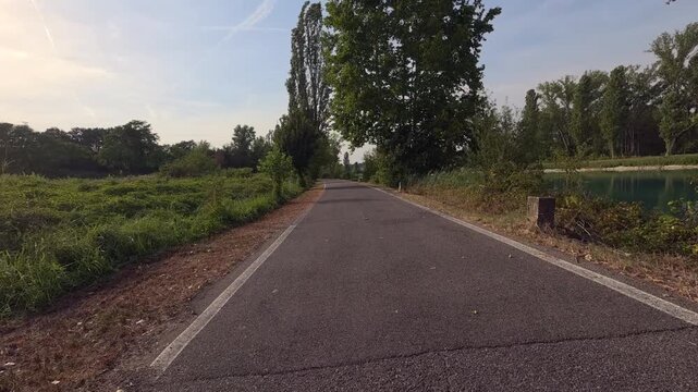 Paved section of the EuroVelo 7 Sun Route, known in Italy as the Ciclovia del Sole, running through a green rural landscape on a sunny summer day. 
