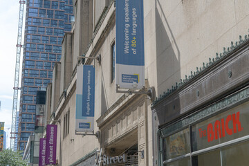 Fototapeta premium wall-mounted projecting banners (Planet Fitness, TMU) outside 444 Yonge St (College Park) incl that of The Brick a furniture store, Toronto
