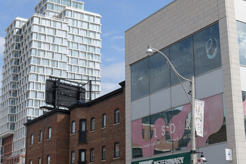 Fototapeta premium (at right) 1073 Yonge St, location of Juno Veterinary, Blue Canoe Yoga, LSDR Studios, and BelloSound, a historic commercial block, and The James a recently built condo tower, Toronto