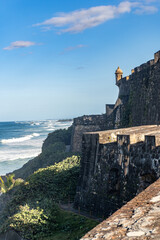Fototapeta premium Castillo San Felipe del Morro or el Morro in San Juan, Puerto Rico. Fortress by the sea. Flags of colonial Spain, Puerto Rico, and United States. Modification to Spaniard fort by US military in WWII.