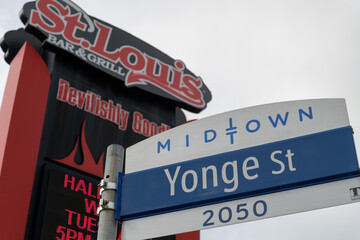 Fototapeta premium road sign at 2050 Yonge St in Midtown Toronto (defocused view of St. Louis Bar & Grill)