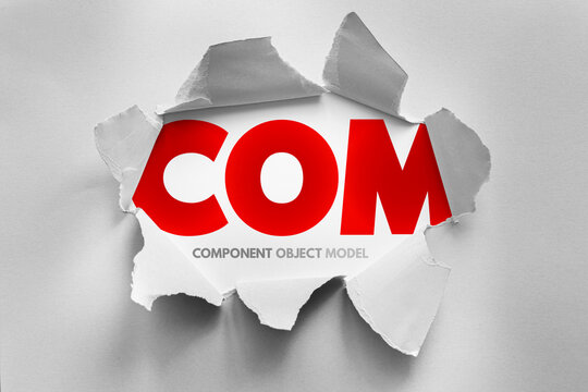 COM Component Object Model text exposed by torn paper effect, software technology concept representing modular programming, reusable components and application interoperability architecture