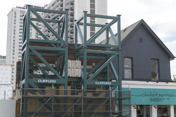 Fototapeta premium historic building with sign at Circles & Squares Bakery Café located at 1909 Yonge St with Clifford facade structure armature at at construction site, Toronto