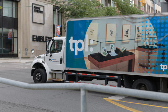 box truck with TPL or Toronto Public Library branding, heading north on Yonge St
