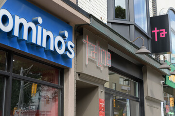 Fototapeta premium building facades and signs of Domino's Pizza (1272 Yonge St) and Taline, an Armenian restaurant (1276 Yonge St), in Toronto