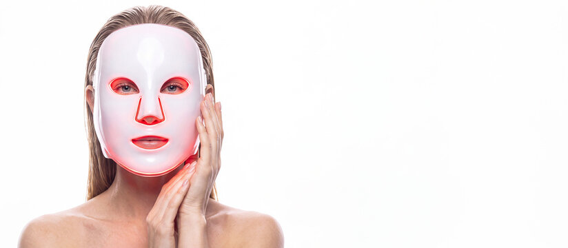 A woman in LED light facial mask. Cosmetology concept, and beauty device, woman advertising of antiaging beauty skin care products, isolated