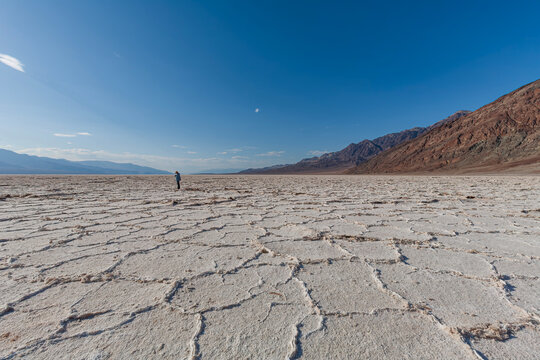 Beautiful wide view of a tourist on salt flats of Badwater Basin in Death Valley