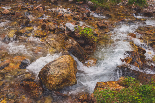 A picturesque view of a river stream in the Alps mountains on a hike to Pra de Dieu hamlet in the Aosta valley (Bionaz, Italy)