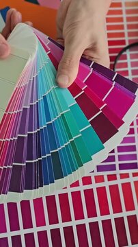 Choosing colors with a color swatch book and matching them to design samples indoors