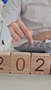 Calculating numbers using blocks 2027 and a calculator in an office setting