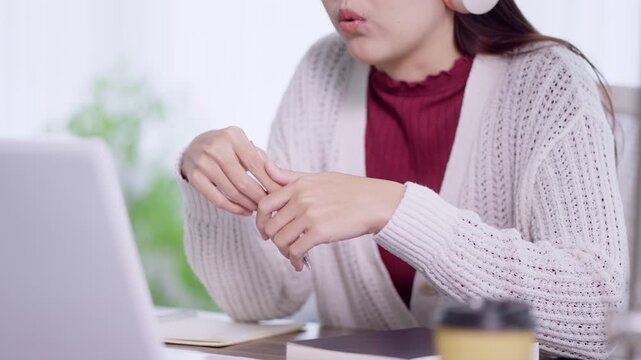 Young Asian woman explaining concept during online video conference in bright home workspace with copy space
