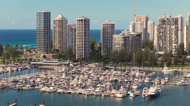 Horizontal aerial footage panning left while trucking right over Southport Marina and the Surfers Paradise skyline during the Gold Coast Marathon, Gold Coast, Queensland, Australia