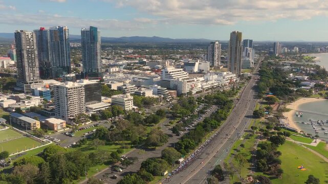 Horizontal aerial footage panning left while dollying backward over Sundale Bridge, Southport and the Gold Coast Marathon, Queensland, Australia