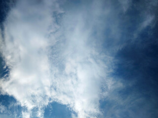 Obraz premium Calm blue sky filled with soft white clouds, perfect for backgrounds