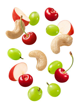Cashew, red apple slices and cherries flying isolated on white background. Real photography.