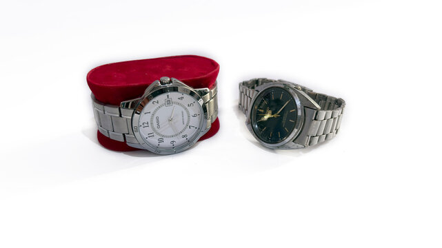 Kediri, East Java, Indonesia &ndash; August 16, 2026: Wristwatch with Metallic Band and Dark Dial Displayed Beside Red Cushion