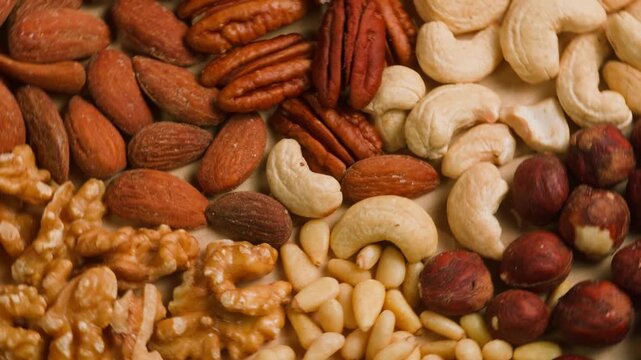 Nuts mix of pecan walnut cashew hazelnut pine and Brazil nuts with peanut on wooden table healthy snack close-up