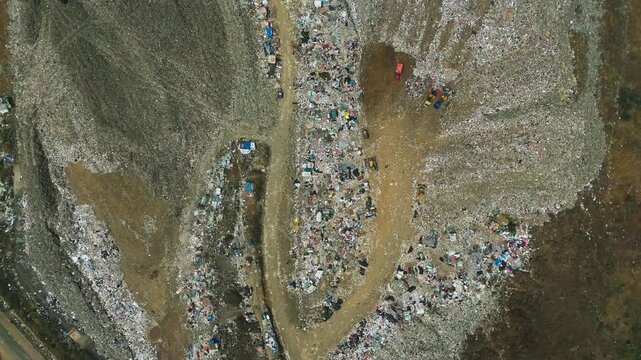 Aerial view of TPA Supit Urang waste processing facility showing large piles of refuse and access roads in Malang, East Java, Indonesia.