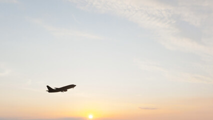 Naklejka premium Commercial passenger airplane flying through the sky and taking off, ideal for aviation, air travel, tourism, transportation, airline, and travel content.