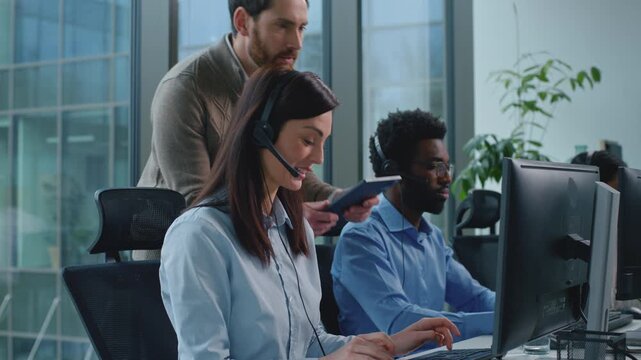 Three multiethnic operators working in call center ceo checking satisfied support woman talking with clients celebrating business success group diversity team work in callcenter boss check good job