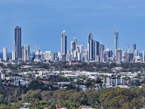 Aerial view of the Surfers Paradise skyline featuring modern skyscrapers and high-rise buildings set against a clear blue sky in Surfers Paradise, Queensland, Australia.