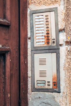 Vintage entry intercom system on an aged building facade. Concept of classic European architecture, residential access, retro security, and urban history.