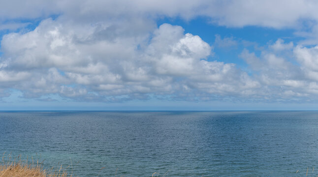 Arromanches-les-Bains, France - 08 10 2026:  Coastal path. Panoramic view of the cliffs and the sea and cloudy sky from top of the path