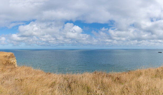 Arromanches-les-Bains, France - 08 10 2026:  Coastal path. Panoramic view of the artificial port with pontoons bridges, the sea, cliffs and the coastal path