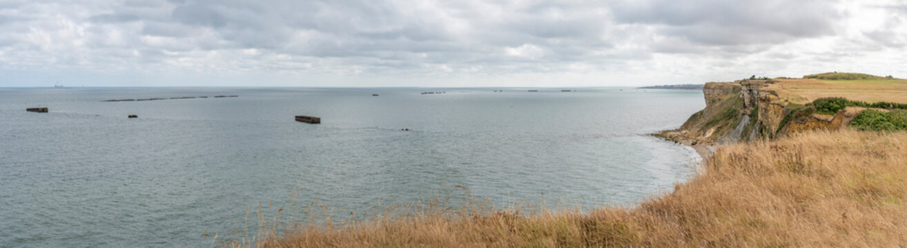 Arromanches-les-Bains, France - 08 10 2026:  Coastal path. Panoramic view of the artificial port with pontoons bridges, the sea, cliffs and the coastal path